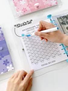 Close-up of a hand coloring the 100 envelope savings challenge tracker in a PVC binder