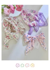 Pañuelos y diademas florales de estilo francés con flores rosas sobre una mesa blanca
