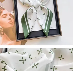 Macro detail view of the green cross pattern on a premium white silk-like square neck scarf