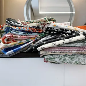 Detailed macro view of a variety of stacked 100% cotton floral patterned handkerchiefs
