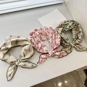 Detailed view of three floral 100% cotton neck scarves with delicate crochet lace edges.