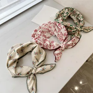 Detailed view of the delicate floral patterns and lace trim on these cotton scarves