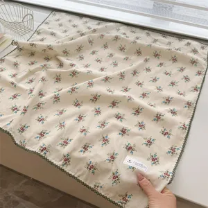 Close-up of floral print 100% cotton square scarf featuring delicate green scalloped lace edges