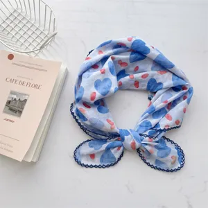 Close-up detail of 100% cotton blue scarf featuring heart patterns and lace edges