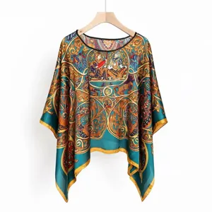 Detailed macro shot of vintage bohemian printed faux silk poncho with irregular hem