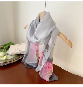 Elegant georgette silk scarf with a pink lotus print displayed on a natural wooden hanger