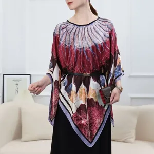 Model wearing a printed silk poncho with bohemian patterns and waist belt detail