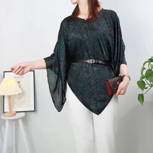 Close-up of elegant dark green floral print silk-like poncho with irregular hemline