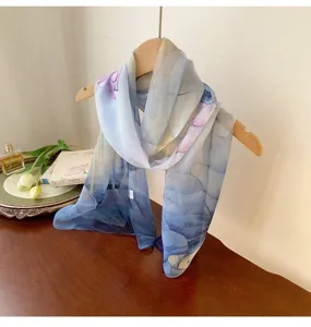 Lightweight blue georgette floral scarf draped on a wooden hanger with elegant decor