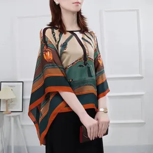 Detailed view of women's printed silk poncho with equestrian chain pattern for sun protection.