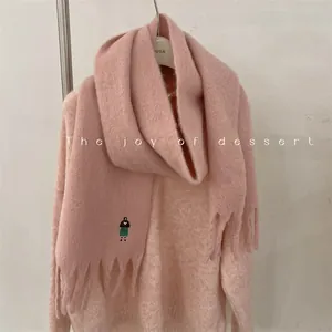 Close-up of pink wool-blend scarf featuring delicate girl embroidery and fringe