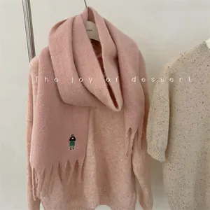Close-up of pink wool blend scarf featuring cute girl embroidery and long tassels