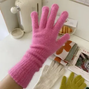 Lange rosa Strickhandschuhe aus Kaninchenhaar in gemütlicher Winteratmosphäre Detailansicht