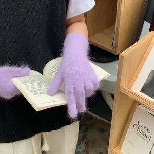 Detailansicht weicher lilafarbener Strickhandschuhe aus Kaninchenhaar beim Lesen
