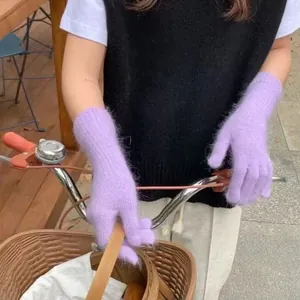 Nahaufnahme von weichen lila flauschigen Strickhandschuhen für winterliche Wärme.