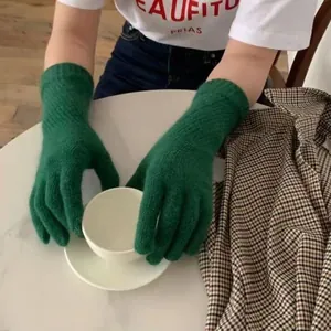 Lifestyle-Foto grüner Strickhandschuhe aus Kaninchenhaar mit weißer Kaffeetasse