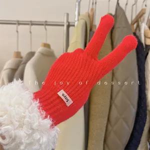 Detail view of vibrant red knitted winter gloves with cozy white faux fur cuff trim.