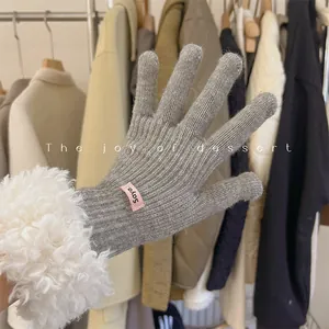 Macro detail of grey knitted touch screen gloves with white fluffy lamb wool cuffs