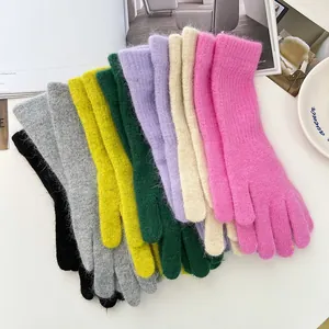 Sammlung bunter, dick gestrickter, flauschiger Handschuhe für Wärme und Komfort im Winter.