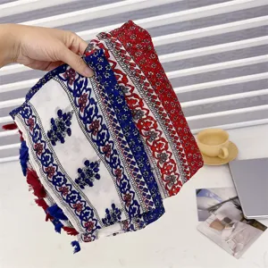 Detailed view of ethnic style scarf with red and blue retro patterns and soft tassels
