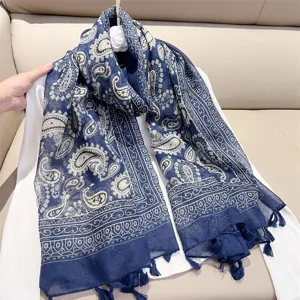 Detail showing a blue and white paisley scarf with elegant tassels in retro ethnic style