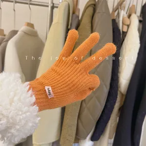 Close-up of orange knitted gloves with soft white lambswool cuffs detail