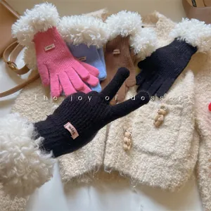 Detailed macro view of warm knitted winter gloves featuring plush faux fur trim in various colors