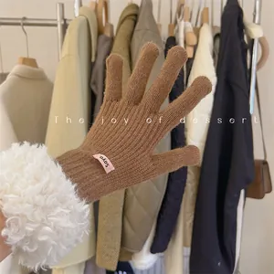 Close-up of brown knit touchscreen gloves with soft white lambswool faux fur cuffs