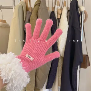 Detail showing the pink knitted glove with white lamb wool trim and touchscreen fingers