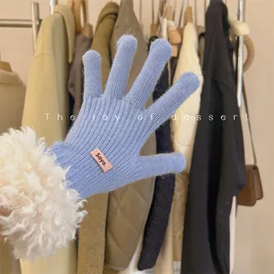 Close-up detail of light blue knitted touch-screen gloves with fuzzy white cuffs.