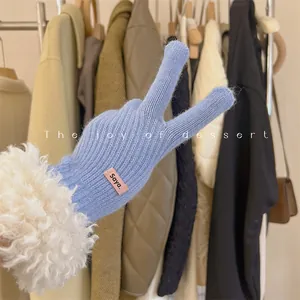 Detailed view of blue knitted touch screen gloves featuring soft white faux lamb wool cuffs
