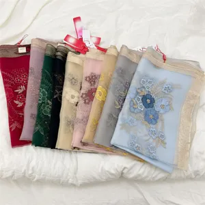 Assorted colors of begonia flower embroidered silk blend scarves displayed in a row