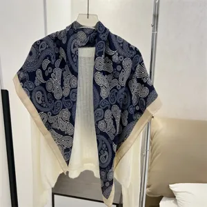 Elegant blue paisley cotton linen square scarf draped over a soft white knitted sweater