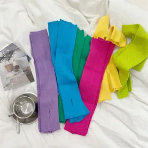 Vibrant collection of colorful knitted long arm warmers with thumb holes on white fabric