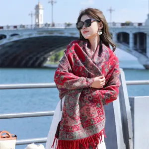Elegant ethnic style red paisley shawl with delicate tassels worn by model in outdoor setting