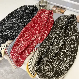 Close-up showing the soft texture of cotton linen square scarves with rose prints