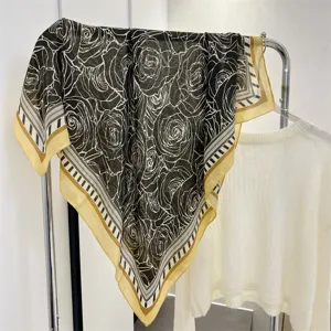 Close-up of square cotton-linen scarf featuring an elegant black and white rose pattern