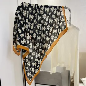 Close-up of elegant floral cotton linen square scarf featuring a tan border design