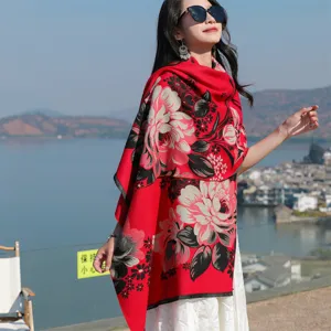 Elegant woman wearing a thick ethnic red floral shawl in a scenic outdoor travel setting