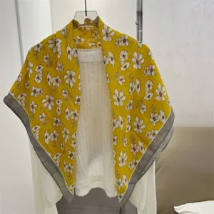 Detail of yellow cotton linen square scarf with white floral pattern and grey border