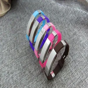 Set of colorful silicone bracelets with stainless steel plates on gray fabric background