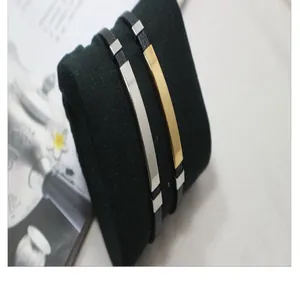 Nahaufnahme von stilvollen Gold- und Silberplatten-Lederarmbändern auf einem schwarzen Kissen