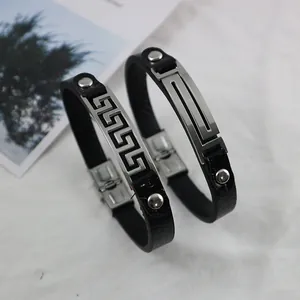 Pair of minimalist black leather and titanium steel bracelets with Greek key pattern