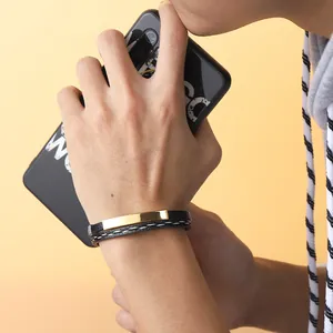 Minimalistisches schwarzes geflochtenes Lederarmband mit goldener Metallplatte