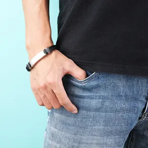 Stylish retro braided leather bracelet with silver metal plate worn on male wrist lifestyle
