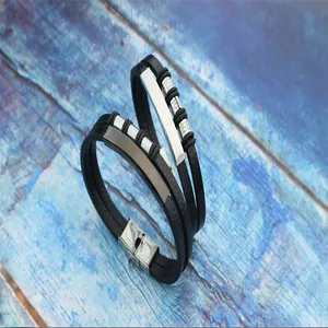 Detailed view of two vintage men's woven leather bracelets with stainless steel accents.