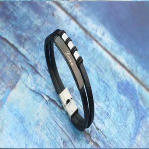 Close-up of men's retro woven leather bracelet with engraved Love stainless steel plate