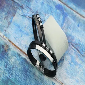 Close-up of men's woven leather bracelet with Love engraving and stainless steel clasp