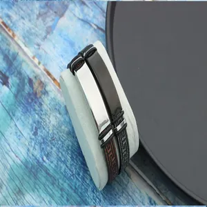 Détail de bracelets tressés pour hommes avec plaques en acier inox et motif grec