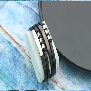 Close-up of men's braided leather bracelet with 'Love' engraved stainless steel plate